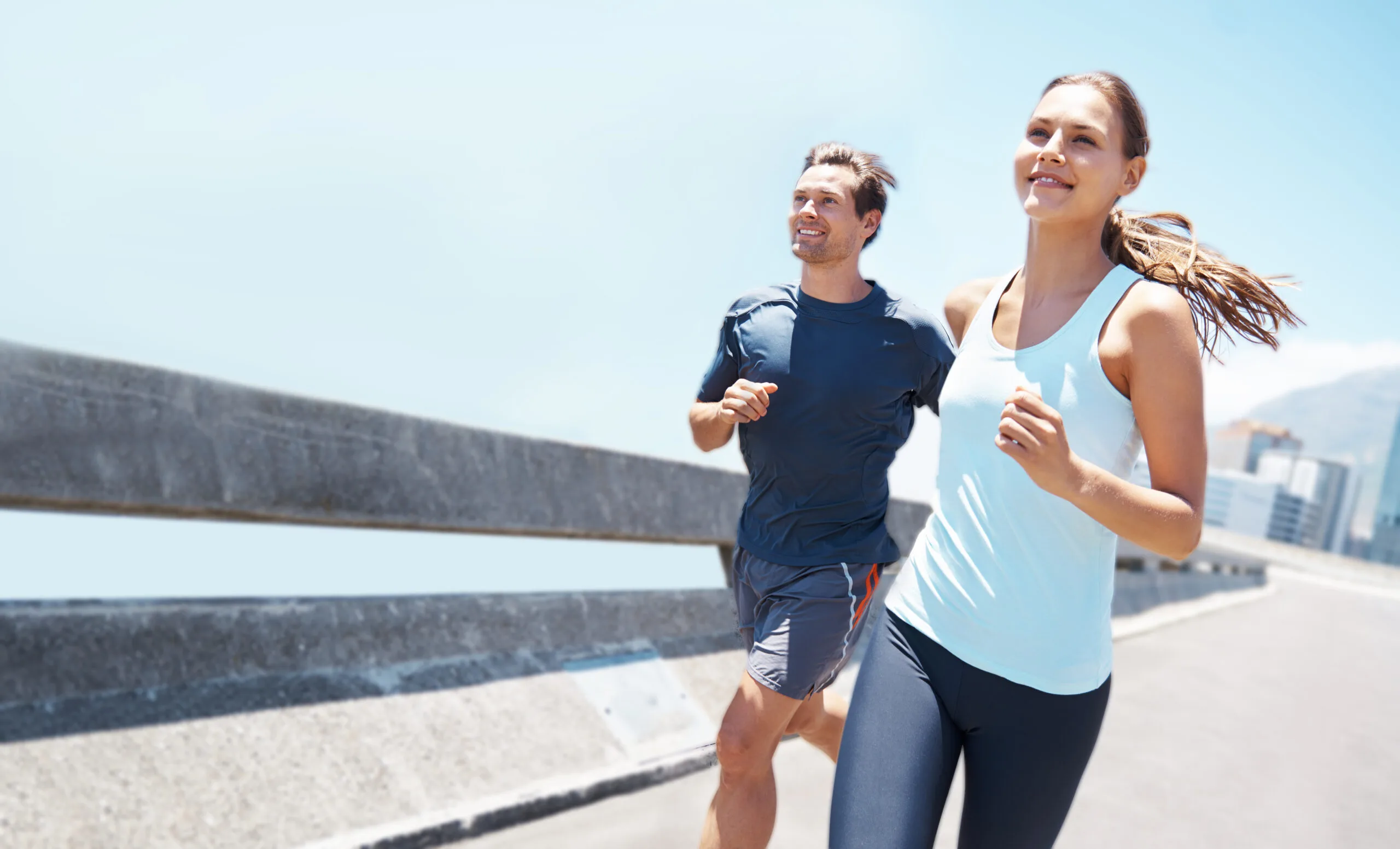 Shot of two young runners training together on the road
